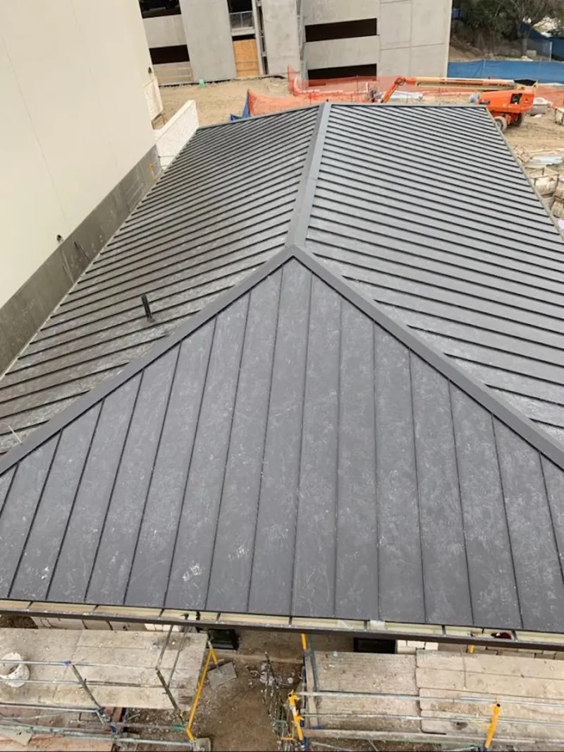 Commercial metal roof construction with crane equipment in Fort Collins